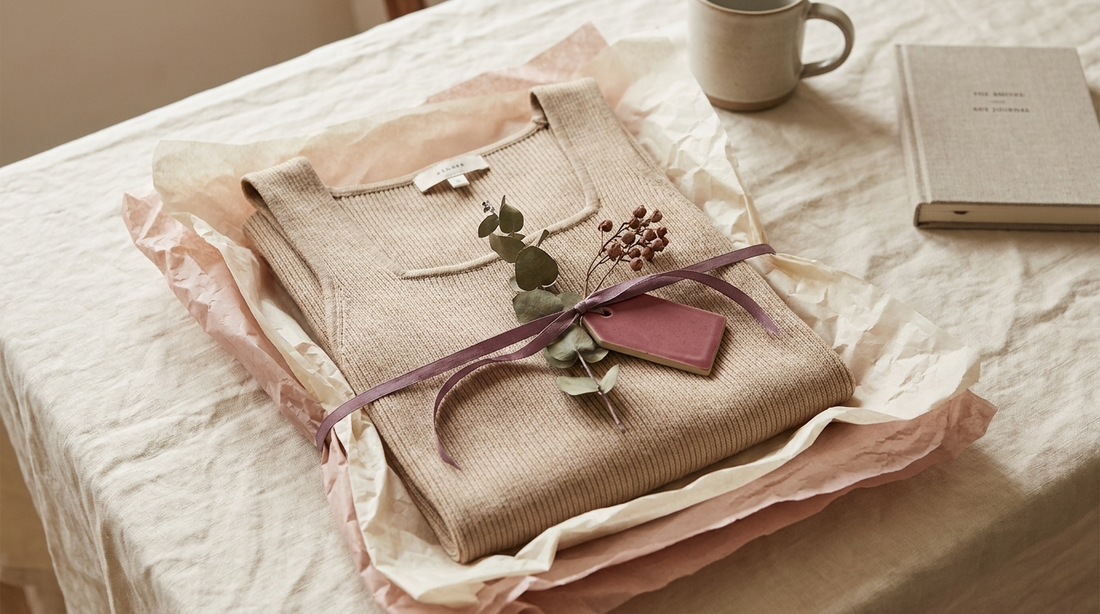 Débardeur beige à maintien intégré plié et présenté comme un cadeau élégant dans du papier de soie avec un ruban